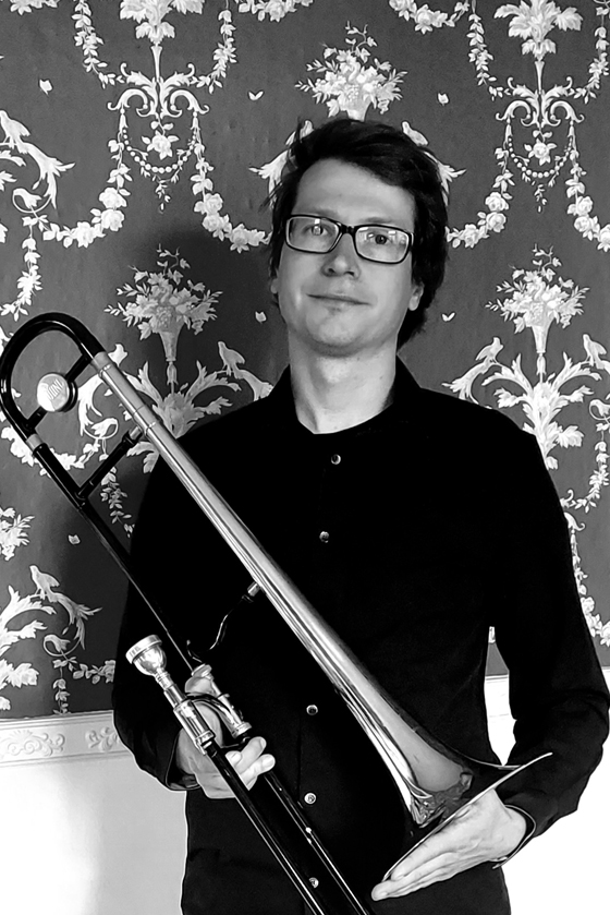 Das Bild zeigt Björn-Michael Röhlich mit einer Posaune in der Hand. Er ist Musiklehrer für Posaune, MFE, Bläserklassen und JeKi an der Musikschule Mittelsachsen.