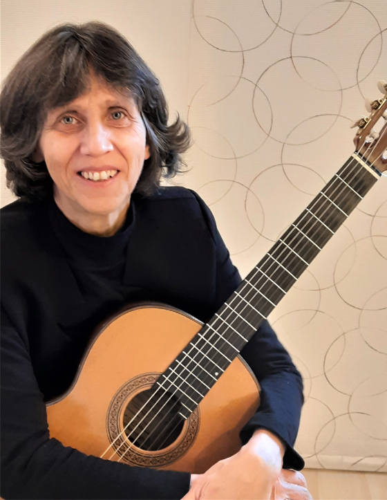 Das Bild zeigt Martina Bunk sitzend mit seiner Gitarre im Arm. Sie ist Musiklehrerin für klassische Gitarre an der Musikschule Mittelsachsen.