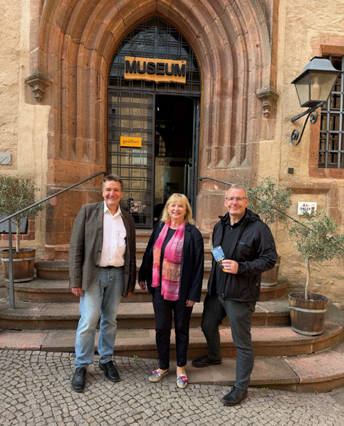 Peter Knierriem, Schlossleiter, Kathrin Hillig, Landrat Sven Krüger stehen vor dem Museumseingang von Schlosss Rochlitz